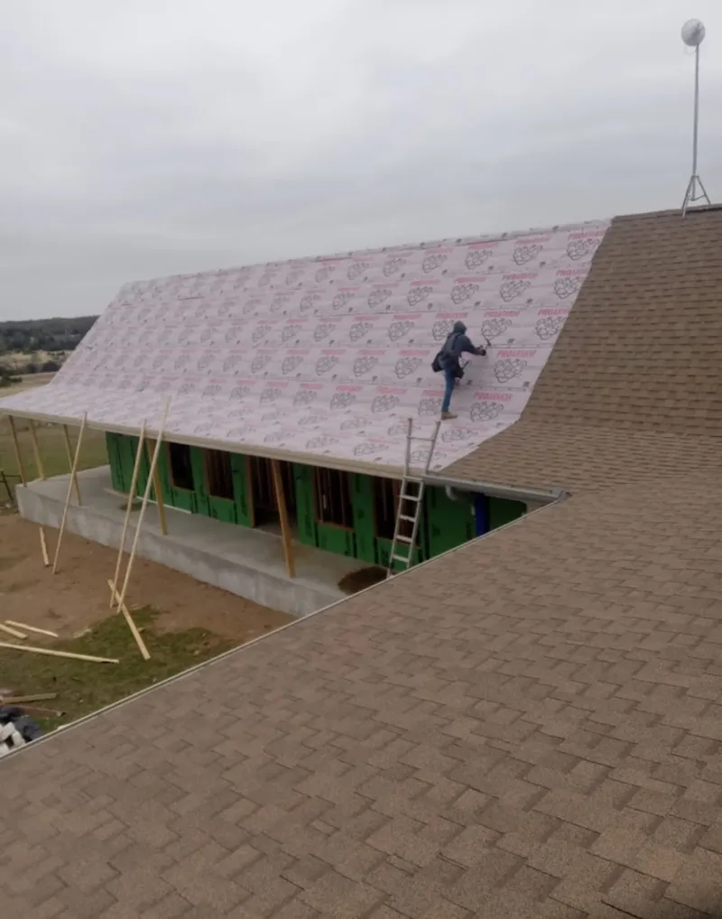 Worker preparing underlayment for a metal roof installation in Nanticoke